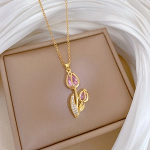 Luxurious rose flower gold necklace with sparkling pink stones on a jewelry box