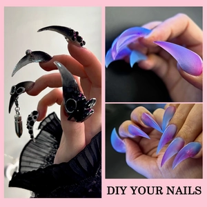 Extra long stiletto nails featuring punk skull charms and blue purple aurora gradient