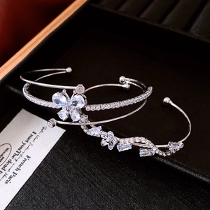Detailed close-up of silver open bracelets with zircon butterfly and floral vine motifs