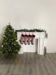 Cozy knit Christmas stockings with red and white stripes hanging on a white fireplace