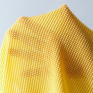 Close-up of vibrant yellow breathable mesh fabric texture for beachwear sets