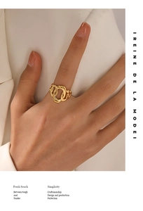 Chunky gold oval stainless steel chain ring shown on a model against a beige suit