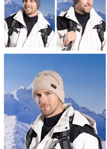 Close-up of beige ribbed knit beanie with mountain logo patch in a snowy outdoor setting