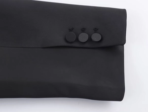 Dettaglio di tre bottoni rivestiti in tessuto nero sul risvolto di un blazer satin