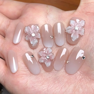 Kurze Kunstnägel mit Nude-Rosa-Verlauf, 3D-Blütenakzenten und funkelnden Strasssteinen
