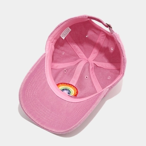 Inside view of pink cotton baseball cap with rainbow embroidery and adjustable strap