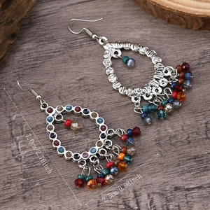 Detail view of ethnic tassel earrings with colorful beads and size measurement labels