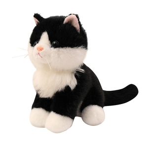Realistic sitting tuxedo cat plush toy with black and white fur and blue eyes