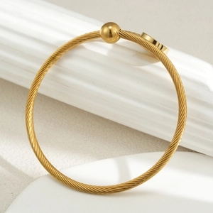 Minimalist gold woven stainless steel bangle with sphere and flat circle design details