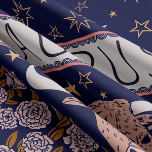 Macro view of navy blue zodiac tapestry fabric showing golden stars and floral patterns