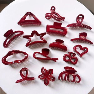 Detailed close-up of dark red glossy hair claws in various vintage minimalist shapes