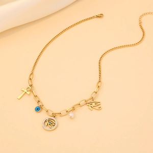 Golden eye cross necklace with blue evil eye beads and pearl pendant on beige fabric