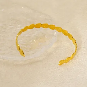 Polished 18K gold plated stainless steel open bangle featuring joined heart motifs