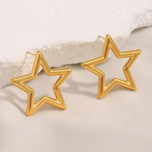 Detailed close-up of 18K gold-plated hollow star earrings on a textured white stone