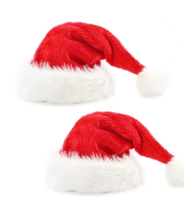Détail de deux bonnets de Noël rouges en peluche avec bordure blanche et pompons doux