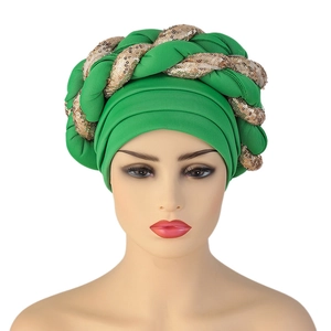 Detailed view of African turban hat with green fabric and gold sequined braid trim