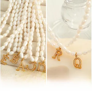 Macro detail of baroque pearl necklace with gold plated 26 initial letter pendants