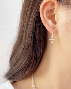 S925 sterling silver minimalist cross pendant earrings worn by a model in a close-up view
