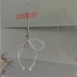 Detailed macro view of handmade crystal bow phone charm with silver star pendant