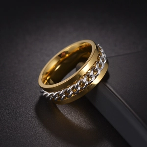 Detail of a rotating titanium steel spinner ring with a gold base and silver chain inlay