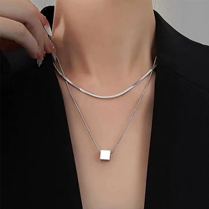 Minimalist double-layered silver necklace with flat snake chain and cube pendant on model