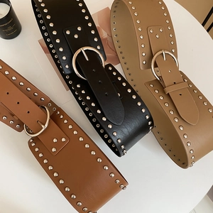 Detail view of vintage PU leather wide belts with metallic rivets and round buckles