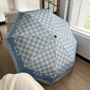 Manual blue and white checkered sun umbrella with wooden handle and floral border