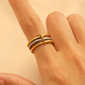 Detailed close-up of interlocking gold and silver rings with cubic zirconia on fingers