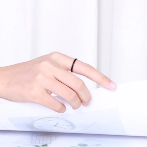 Minimalist black thin ring on finger flipping book pages in a lifestyle scene
