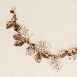 Close-up of vintage bridal headband with gold leaves and transparent crystal beads