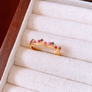 Close-up of a vintage gold plated flower ring with red and green zircons in a jewelry box