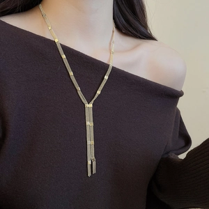 Detailed close-up of a layered gold Y-necklace with elegant multi-chain tassel pendant