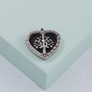 Silver stainless steel heart pendant with Tree of Life engraving on a geometric stand