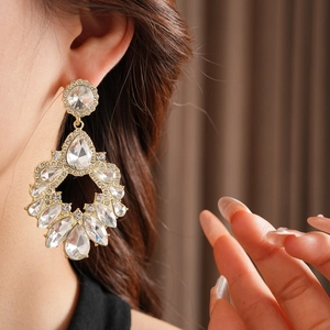 Vue rapprochée de boucles d'oreilles dorées en forme de larme avec cristaux brillants