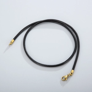 Close-up of black braided leather necklace cord with a golden lobster clasp and end caps