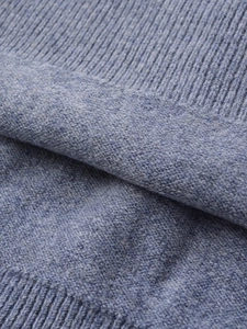 Close-up of blue cashmere blend knit fabric showing soft ribbed texture and fibers