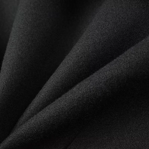 Close-up detail of high-quality black wool fabric texture on short elegant women's jacket