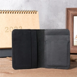 Macro view of interior card slots in a vintage black genuine leather wallet on wood