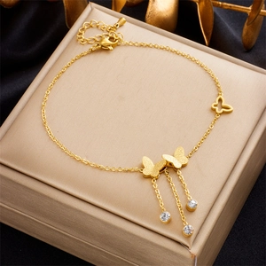 Elegant gold butterfly anklet with sparkling tassels and crystals on a luxury box