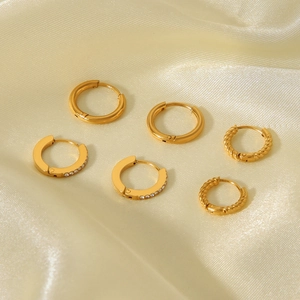 Detailed set of three 18K gold-plated stainless steel hoop earrings on gold silk background