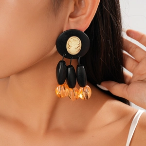 Close-up of retro relief portrait earrings featuring black acrylic and wood beads