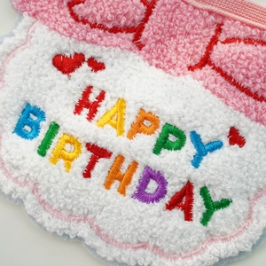 Detailed close-up of pink felt hat with Happy Birthday embroidery for dog party