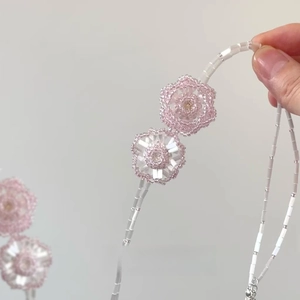 Detail of handmade beaded flower pendant necklace with pink crystal beads and sweet design