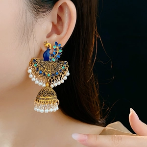 Close-up of vintage Jhumka earrings with peacock enamel and white pearl tassels