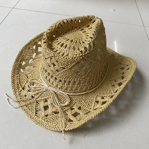Detail of hand-woven straw cowboy hat featuring hollow patterns and a thin decorative rope