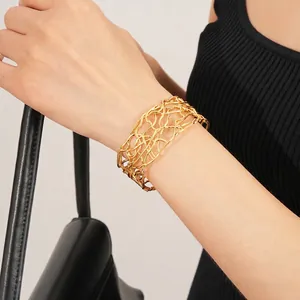 Bracelet jonc ouvert doré avec design ajouré croisé de style minimaliste chic pour femme
