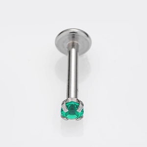 Vista macro dettagliata del piercing in titanio argento con zircone verde e base piatta