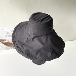 Close-up of black wide brim sun hat showing fine twill texture and large coverage