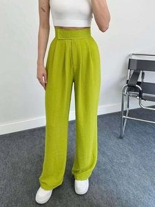 Détail du pantalon large à taille haute vert citron avec une texture de tissu unique