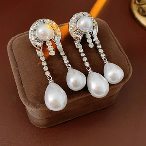 Dettaglio degli orecchini pendenti in argento con perle e cristalli su scatola in velluto